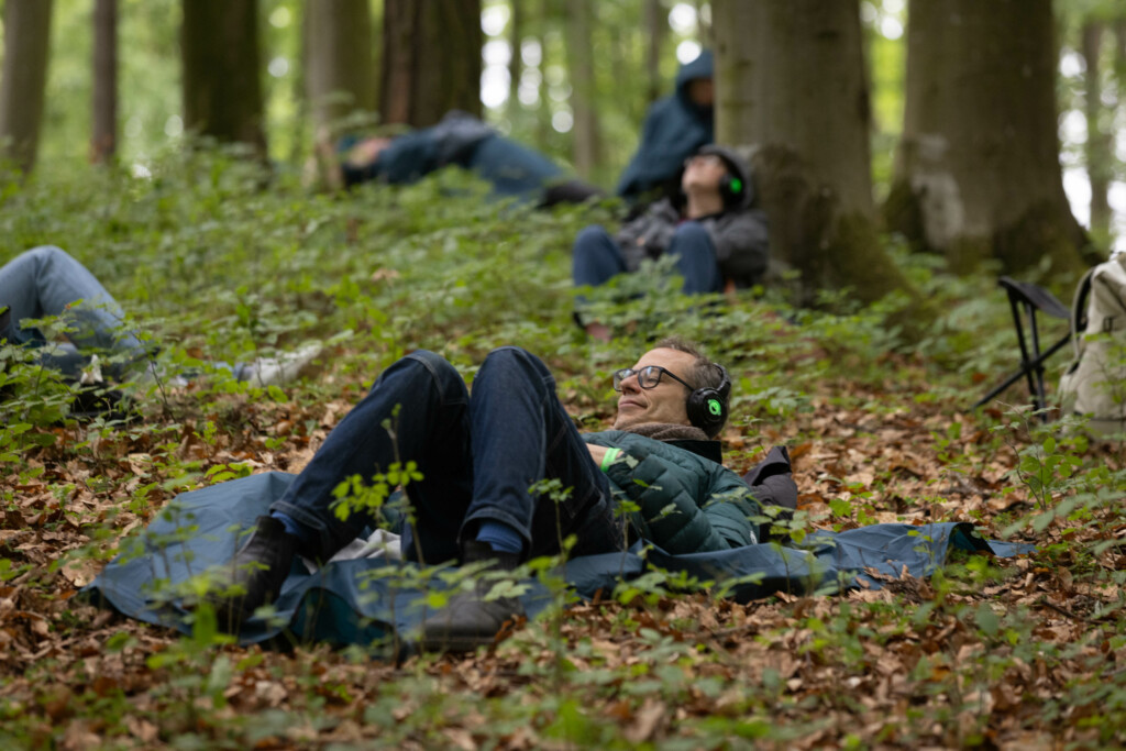Stefan Kaegi liegt auf dem Waldboden