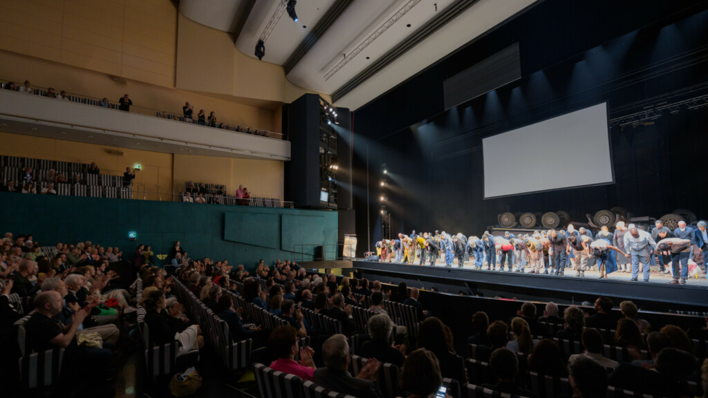 Opernsängerinnen ud Opernsänger verbeugen sich auf der Bühne vor Publikum